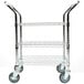 A chrome metal cart with three shelves and black wheels.