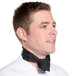 A man wearing a black poly-cotton Chef Revival neckerchief with a bandana design.