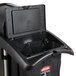 A black Rubbermaid housekeeping cart trash container with a black bag inside.