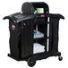 A Rubbermaid black housekeeping cart with wheels and a cover.