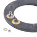 A black circular heating element with yellow screws and nuts.