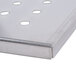 A stainless steel Nemco reservoir lid with holes.