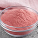 A white bowl of pink Great Western Applicious Candy Apple Coating powder.