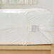 A Bargoose white vinyl bed bug proof mattress cover on a bed with a white sheet.