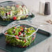 Two Dart ClearPac plastic containers of salad with flat lids on a counter.