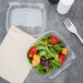 A salad in a Dart plastic container with a clear dome lid.