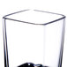 A close up of a clear Thunder Group plastic square shot glass on a white surface.