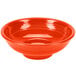 A white china pedestal serving bowl with a red surface and ripples on the edge.