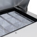 The interior of a Traulsen refrigerated sandwich prep table with clear plastic containers inside.