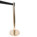 A gold metal stanchion pole with a black retractable tape.