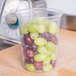 A Solo clear plastic deli container filled with red and green grapes.