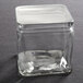 An American Metalcraft square PET jar lid on a clear glass container.