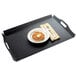 A black Cal-Mil room service tray with a pastry, fork, and knife on it.
