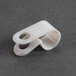 A Waring cable clamp, white plastic with holes.