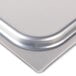 A stainless steel lid on a silver steam table pan.