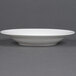 A CAC white bone china soup bowl on a gray surface.