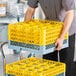 A Noble Warewashing 16-compartment gray full-size glass rack with four yellow extenders.