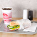 Durable Packaging deli sheets wrapped around a sandwich on a tray with a drink.