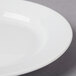 A close up of a CAC Harmony white porcelain plate with a rim.