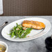 A CAC Harmony super white porcelain platter with salmon and green beans on it.