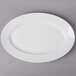 A CAC Harmony super white porcelain platter with a white rim on a gray surface.