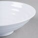 A close-up of a white GET Milano melamine bowl with a white rim on a gray surface.