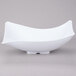 A close-up of a white GET San Michele Flare Bowl with a curved shape.