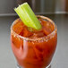 A glass with a Bloody Mary garnished with Rokz Natural Bloody Mary Infused Cocktail Rimming Salt and a celery stick.
