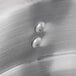 A close-up of a metal surface with a circular Thunder Group aluminum double boiler inset.