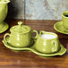 A Fiesta Lemongrass china sugar and creamer tray set on a wooden surface with a creamer and sugar bowl.