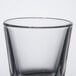 A clear Libbey shot glass with a black rim on a white background.