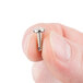 A person holding a small silver screw.