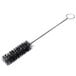 A black cleaning brush with a metal handle.