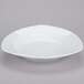 A CAC white china pasta bowl with a small rim on a gray surface.