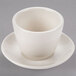 A close up of a Homer Laughlin Ivory Sake Cup and Saucer on a white background.