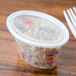 A close-up of a Pactiv Newspring oval plastic souffle container with food in it.
