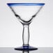 A close-up of a Libbey martini glass with a blue rim and clear base.