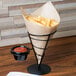 A brown paper cone with a Choice natural kraft liner filled with french fries and red sauce.