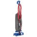 A red and blue Oreck upright vacuum cleaner with red cables and a hose.