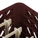 A close-up of a burgundy Vollrath Traex peg rack with plastic holders.