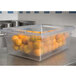 A Rubbermaid clear polycarbonate food storage box with oranges inside.