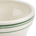 A white china bowl with a green striped border.