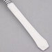 A white plastic teaspoon with a silver stainless steel look tip.