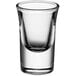 A close-up of a clear Acopa shot glass with a small rim.