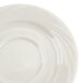 A close-up of a CAC Garden State bone white porcelain saucer with a circular pattern.