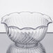 A clear glass Dinex tulip bowl with a rippled design on a reflective surface.