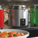 A Vollrath Retro stock pot kettle on a counter with other large pots.
