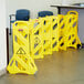 A group of yellow Rubbermaid safety barriers.