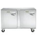A Traulsen stainless steel undercounter freezer with two left hinged doors on wheels.