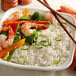 A white plate of Riceland white long grain rice with shrimp and vegetables.